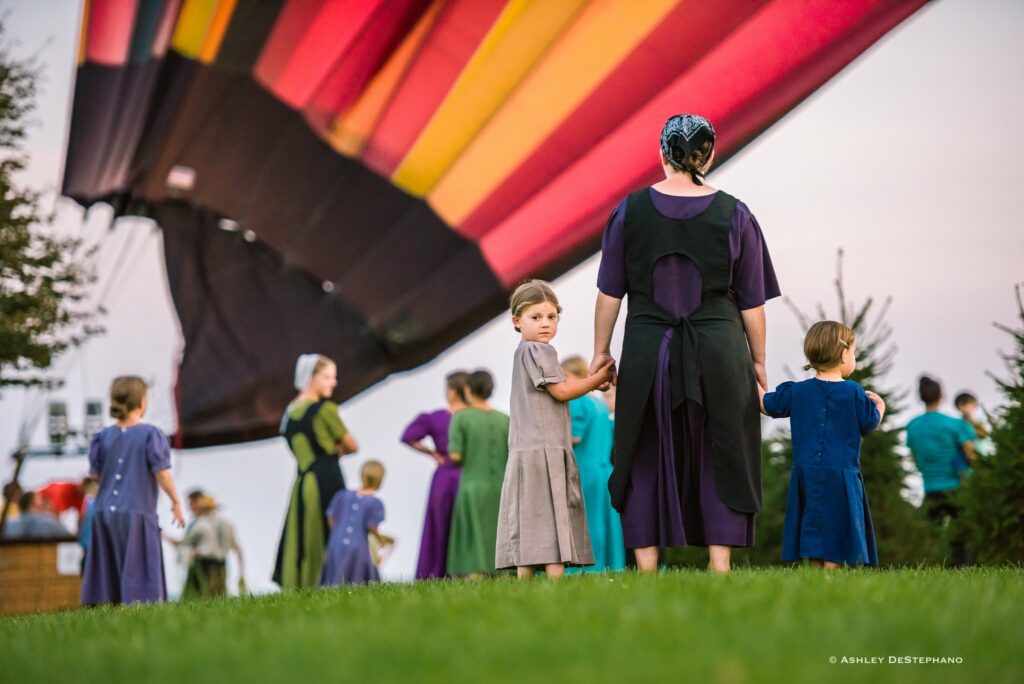 Amish people gathering to see a hot air balloon launch