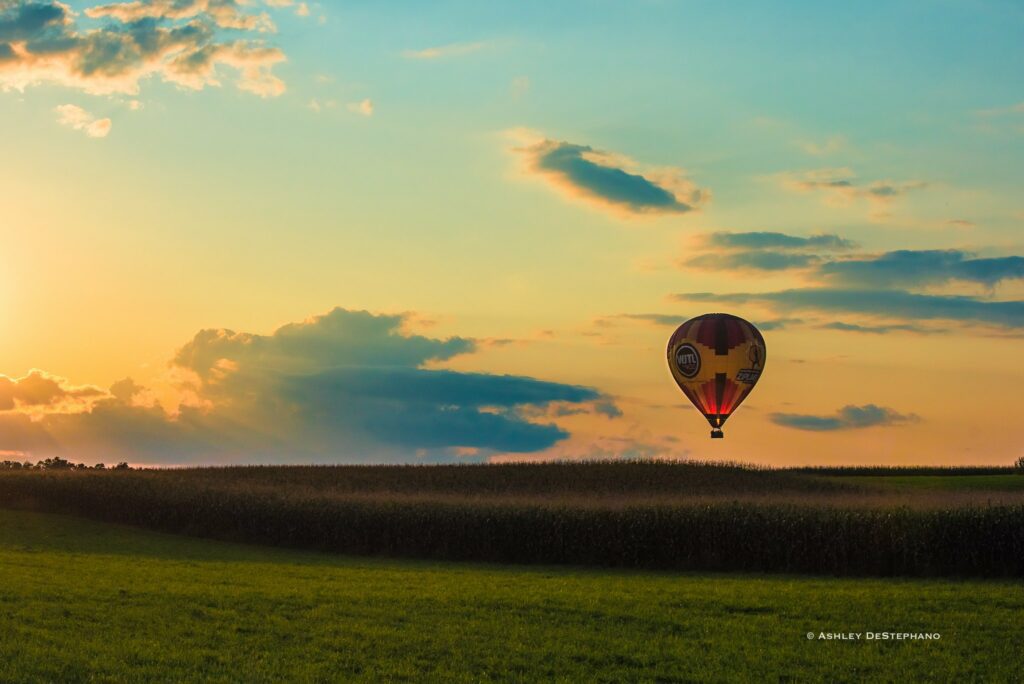 A hot air balloon hovering over a field in Lancaster, PA | Lancaster Balloon Rides