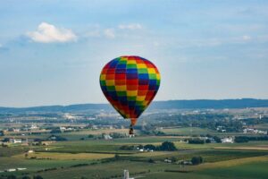 A hot air balloon launching over fields in Amish Country, PA | Lancaster Balloon Rides