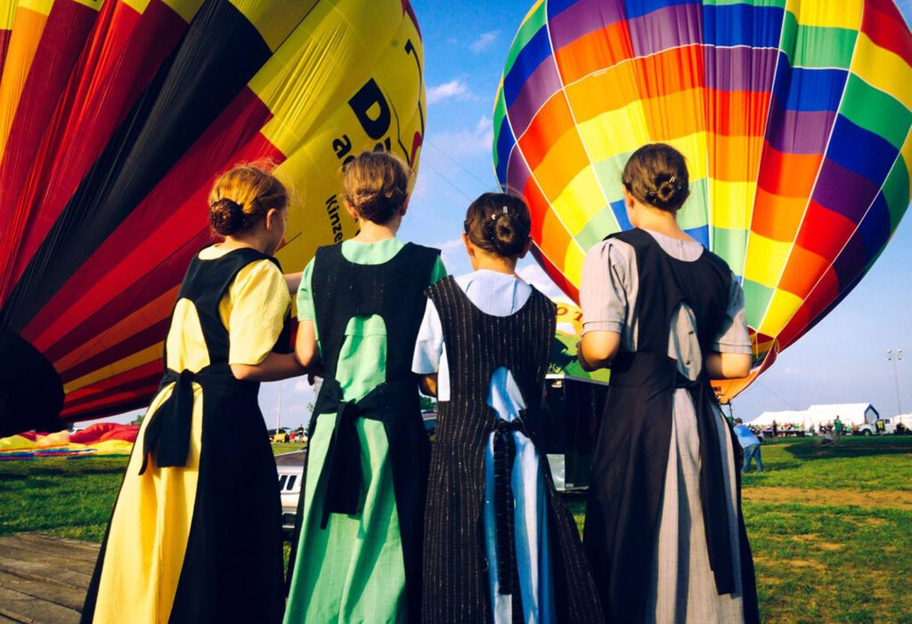 Amish children watching a Lancaster Balloon Rides hot air balloon get blown up in Amish Country, PA. Just a short drive from Hershey, PA