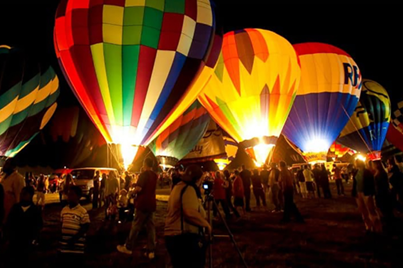 Hot air balloons preparing for a night time launch at a balloon festival