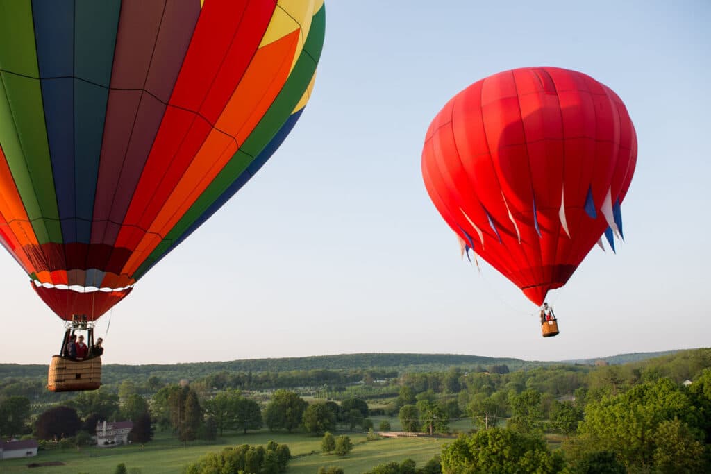 Two Lancaster Balloon Rides hot air balloons floating over the historic wooded skyline of Gettysburg, PA.